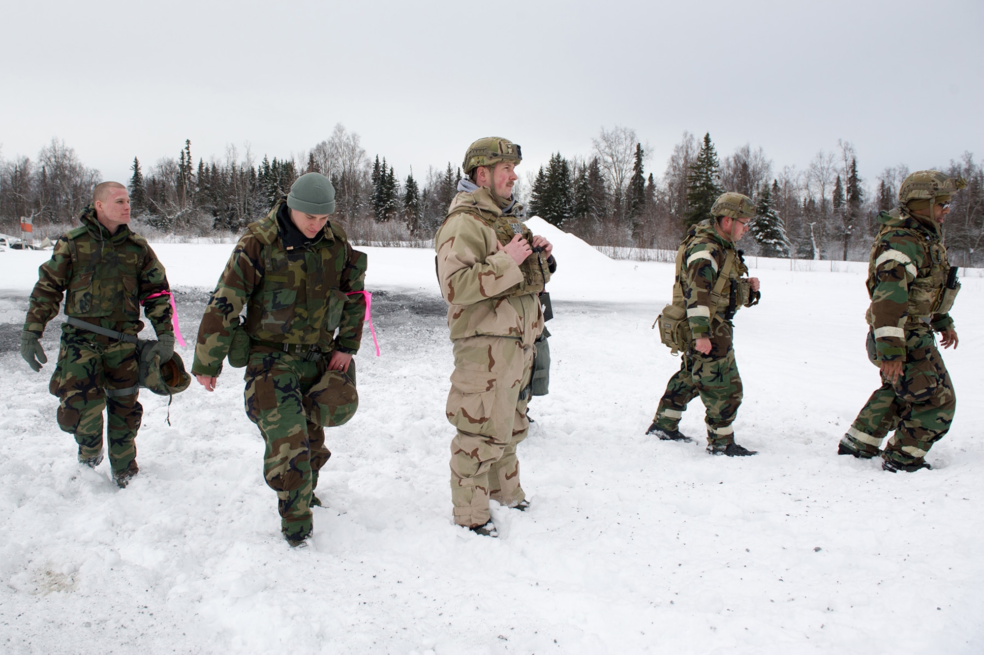 Air Force Staff Sgt. Zacheriah Sekula, center, assigned to the 673d Civil Engineer Squadron, Explosives Ordinance Disposal Flight, watches his fellow Airmen walk out away from a blast area after a live-fire demolitions exercise that was conducted in Mission Oriented Protective Posture 4 on Joint Base Elmendorf-Richardson, Alaska, Feb.14, 2018.  The Airmen were conducting EOD training in a simulated chemical weapons contaminated environment.