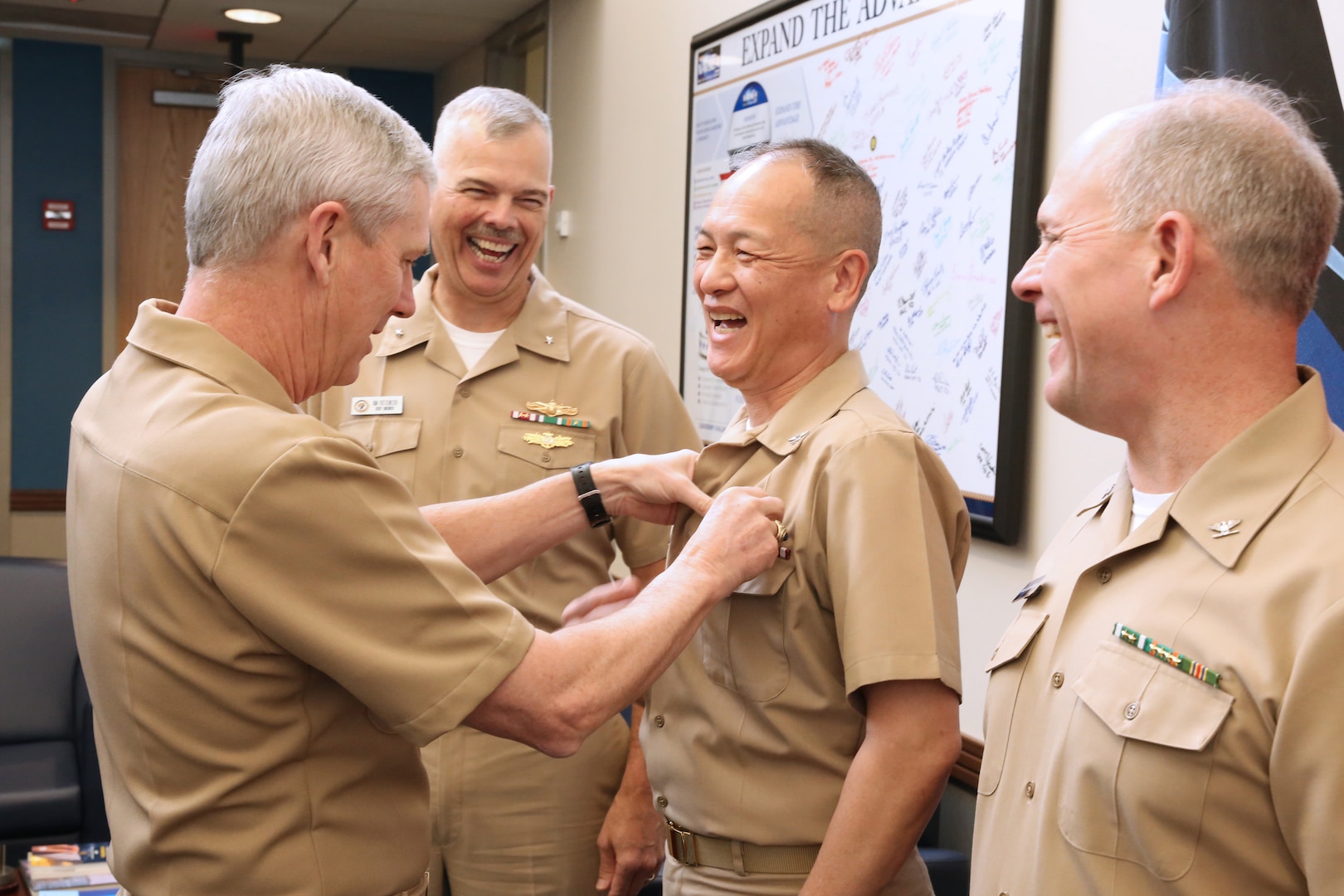 Vice Adm. Tom Moore pins Capt. Huan Nguyen, deputy chief information officer, NAVSEA;  with an Engineering Duty Officer (EDO) qualification insignia as recently pinned Rear Adm. Ronald Fritzemeier, Space and Naval Warfare Systems Command (SPAWAR) chief engineer;  and soon to be pinned Capt. Mark Mclean, principal acquisition program manager with Acquisition and Finance, Program Executive Office Littoral Combat Ships.