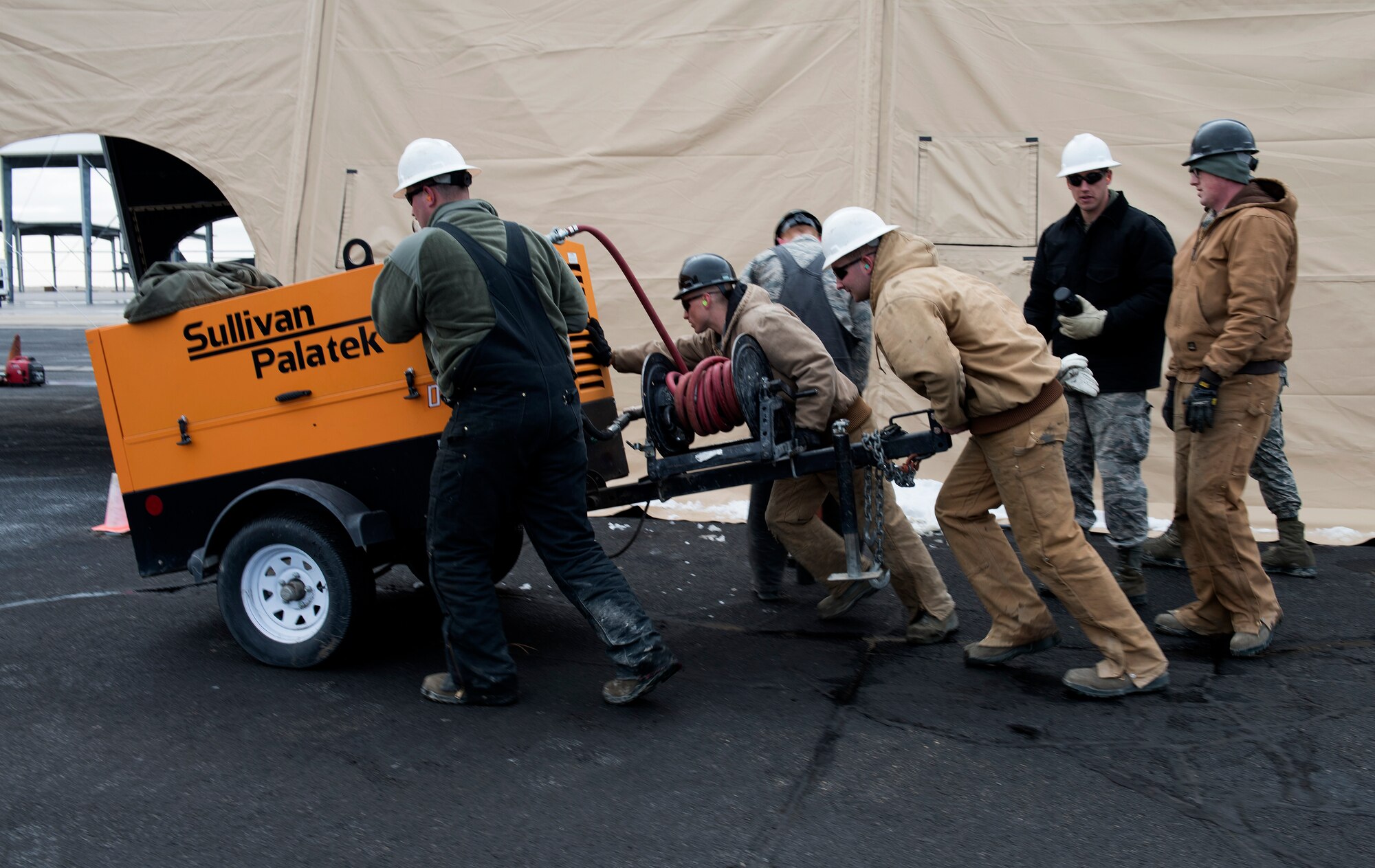 366th Civil Engineer Squadron Airmen move heavy equipment in support of erecting a temporary maintenance facility.