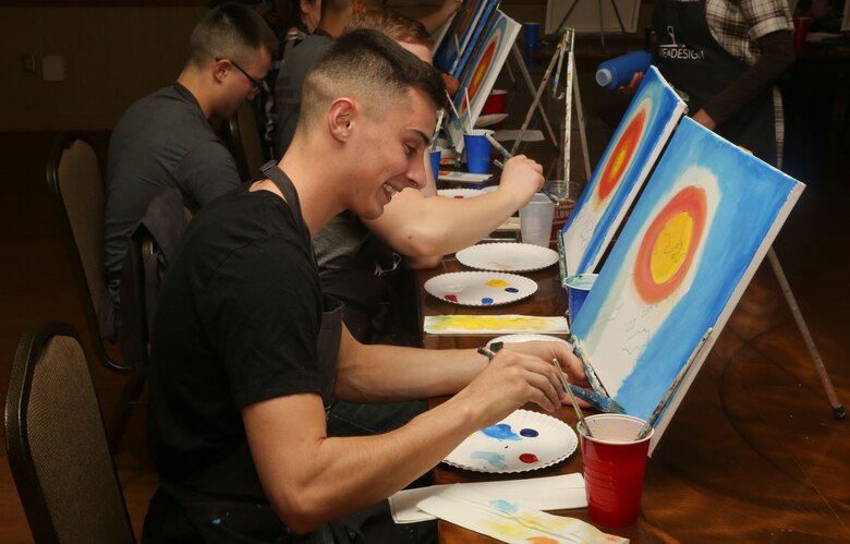 Marines paint a picture during a “Singles Painting Party” aboard Marine Corps Air Station Beaufort, Feb. 14. The
Marines were recreating a painting of the flag raising during the Battle of Iwo Jima. The party was led by Wine
and Design, a company that offers step by step help to encourage others to create their own piece of art.