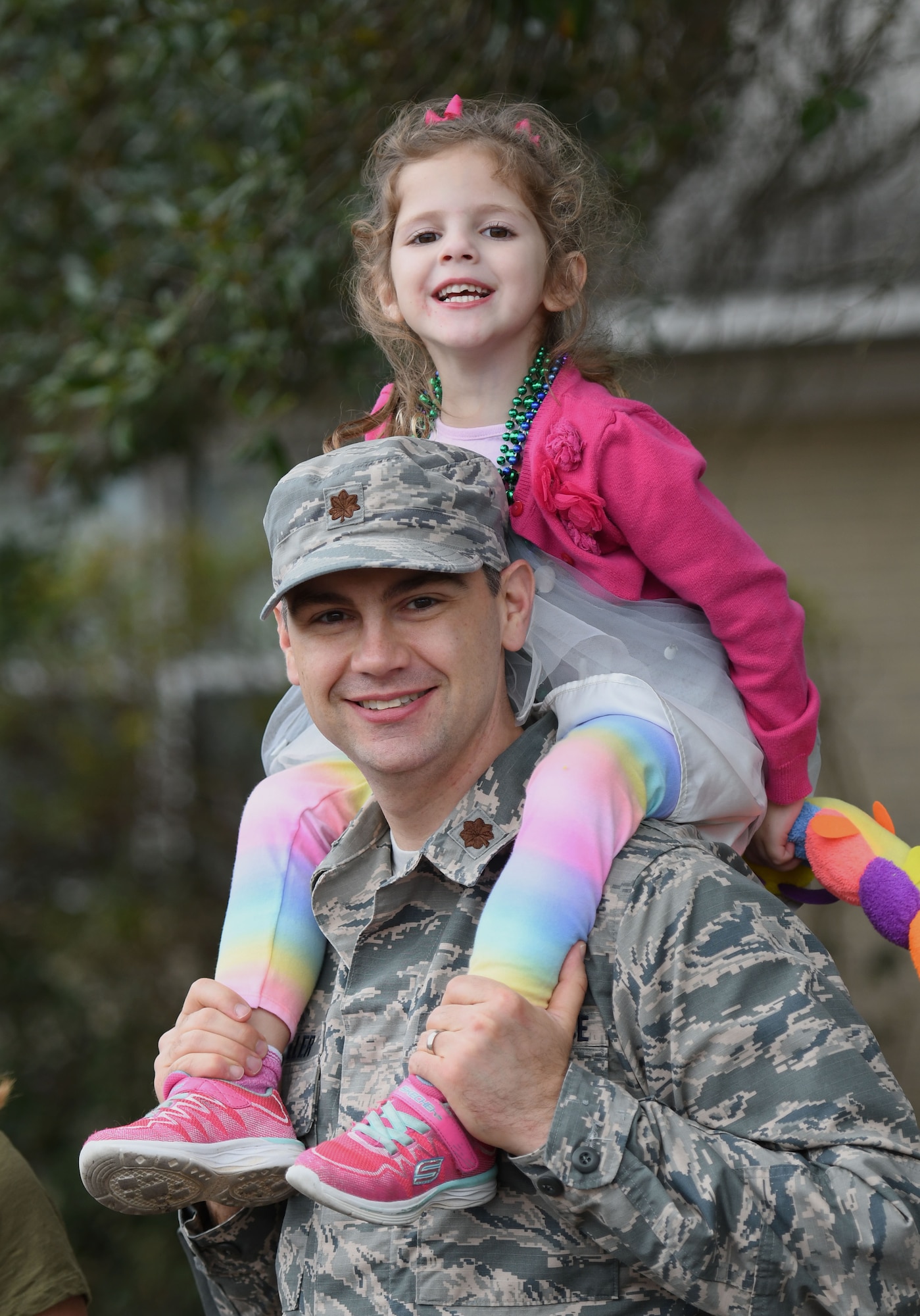 Maj. Garrett Miller, 81st Medical Group physician assistant program director, and his daughter, Reagan, attend the Jeff Davis Elementary School Mardi Gras parade Feb. 9, 2018, in Biloxi, Mississippi. Keesler leadership and other base personnel participated in the festivities. (U.S. Air Force photo by Kemberly Groue)