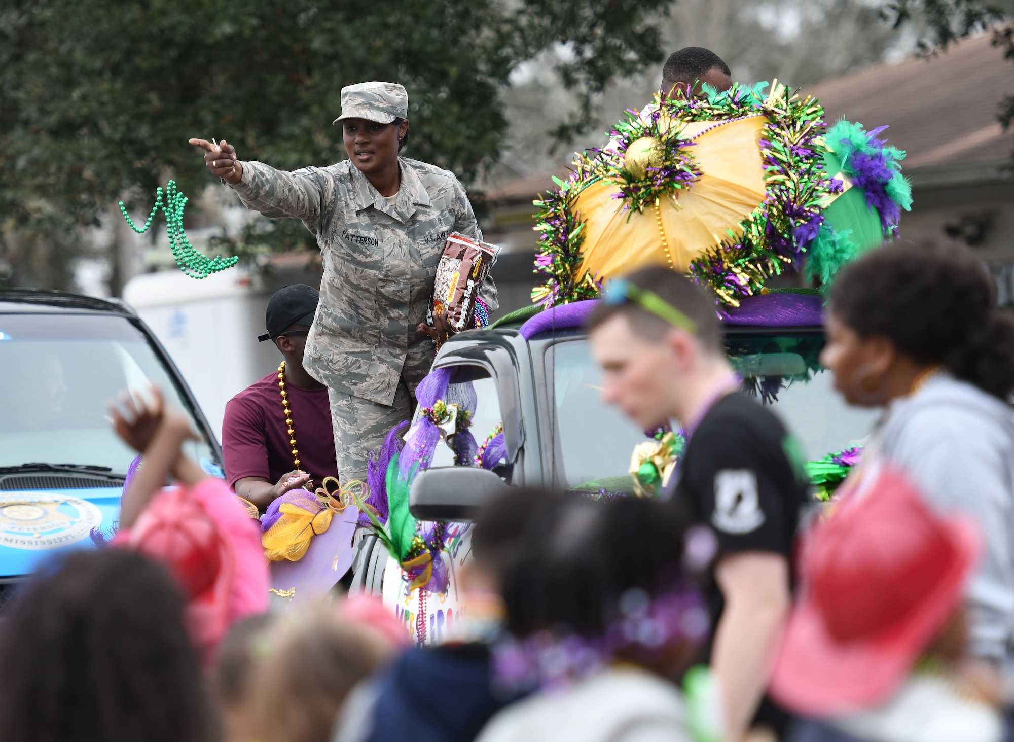 Senior Master Sgt. Tiffany Patterson, 81st Force Support Squadron career assistance advisor, throws beads during the Jeff Davis Elementary School Mardi Gras parade Feb. 9, 2018, in Biloxi, Mississippi. Keesler leadership and other base personnel participated in the festivities. (U.S. Air Force photo by Kemberly Groue)