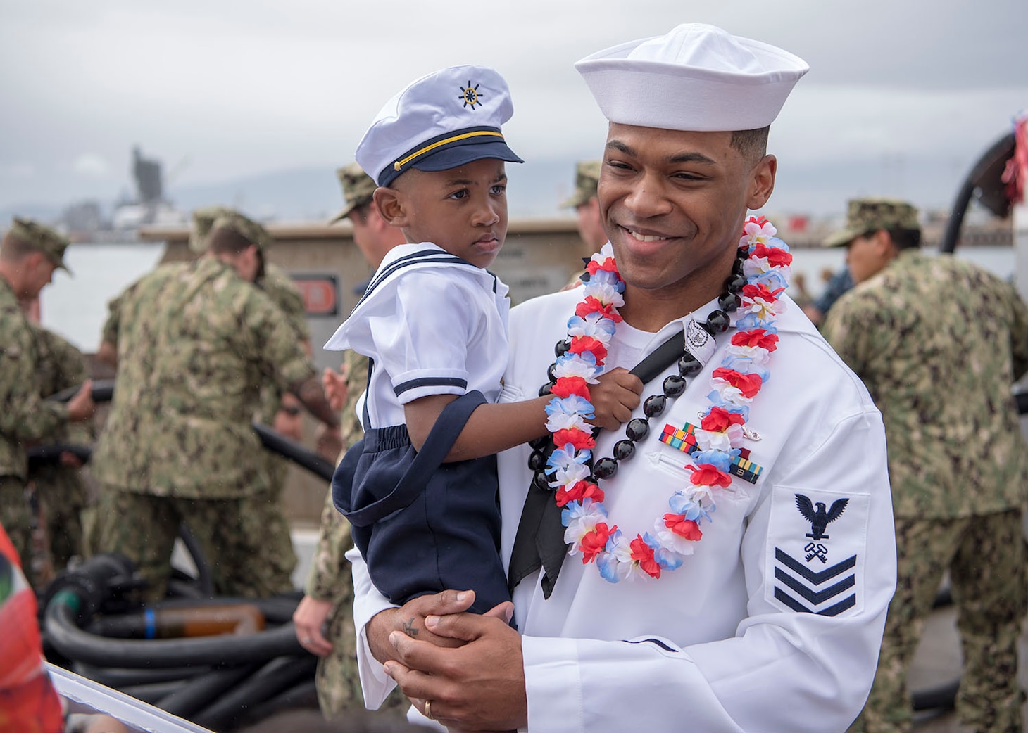 USS Texas (SSN 775) and native of Chicago, Illinois, holds his son on the submarine pier in Joint Base Pearl Harbor-Hickam, Feb. 14.