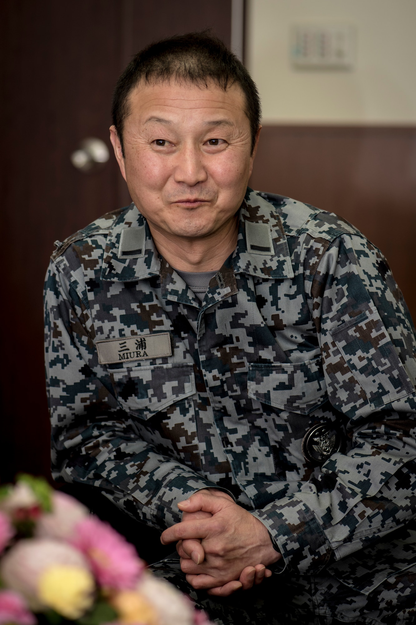 Japan Air Self-Defense Force Warrant Officer Junji Miura, the 3rd Air Wing command chief, smirks as he discusses his friend's, JASDF Warrant Officer Tsuyoshi Endo, the former 6th Air Defense Missile Group chief and Senior Noncommissioned Officer Association president, retirement plans with U.S. Air Force Master Sgt. Cesar Ventura, a 35th Fighter Wing inspector general vertical inspections planner, at Misawa Air Base, Japan, Feb. 14, 2018. Over the past four years, Ventura worked with Miura and Endo planning and organizing bilateral events including dining outs and tug-of-war competitions. His mastery of their culture and language helped him grow so close with the two warrants that now they call him, "like family." (U.S. Air Force photo by Tech. Sgt. Benjamin W. Stratton)