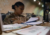 Senior Airman Astrid Hernandez, 455th Expeditionary Force Support Squadron contracting officer representative, looks over her checklist in The Rock fitness center Feb. 13, 2018 at Bagram Airfield, Afghanistan.