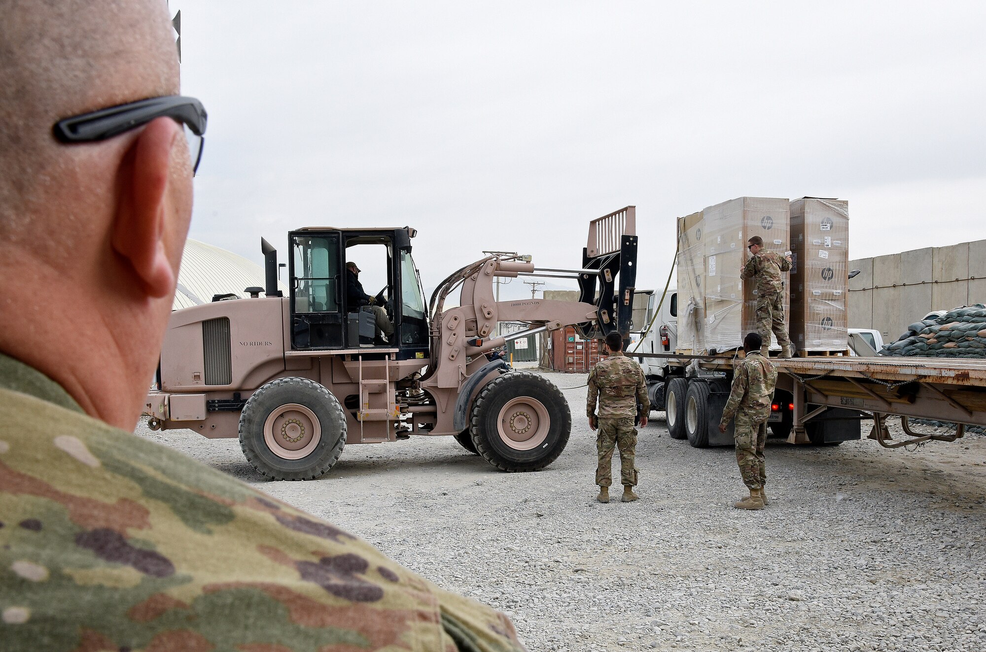 Airmen from the 455th Expeditionary Communications Squadron load supplies onto a flatbed Jan. 3, 2018 at Bagram Airfield, Afghanistan.