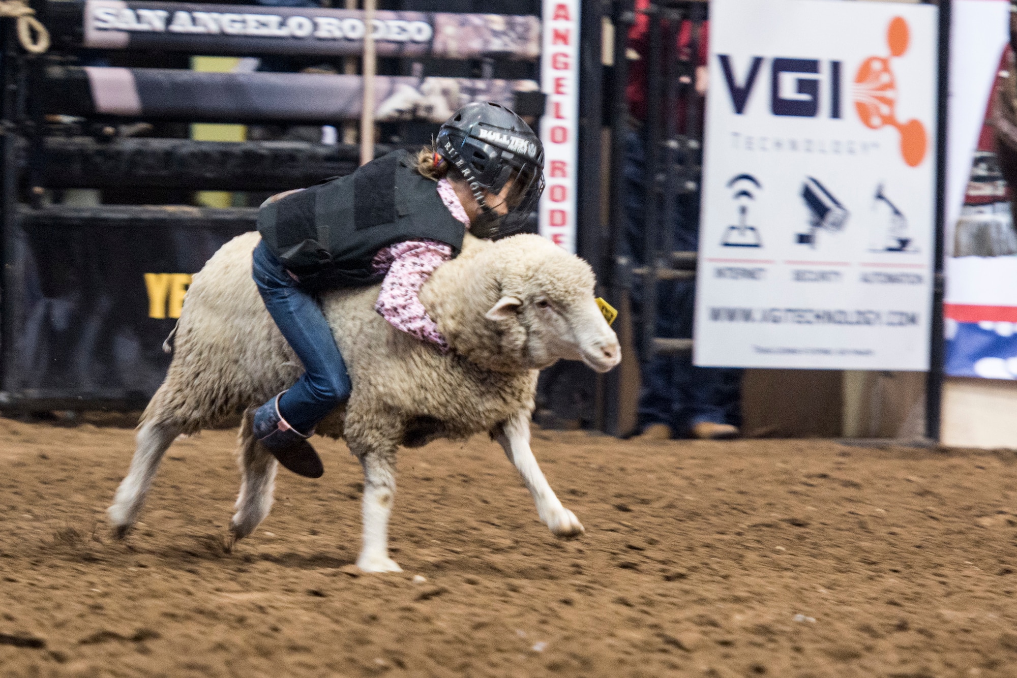 Neveah Wilmore, Goodfellow family member, participates in the mutton busting competition during Military Appreciation Night at the San Angelo Stock Show and Rodeo held at the Foster Communications Coliseum, Feb. 14, 2018, San Angelo, Texas. Mutton busting is an event where children ride race sheep and attempt to hold on for six seconds. (U.S. Air Force photo by Aryn Lockhart/Released)
