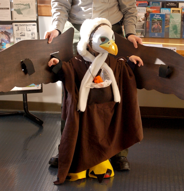 A young visitor tries out a few of the bald eagle's most noticeable adaptations: talons for hunting, beaks for tearing and wings for flying. Eagle Watch, 2017.