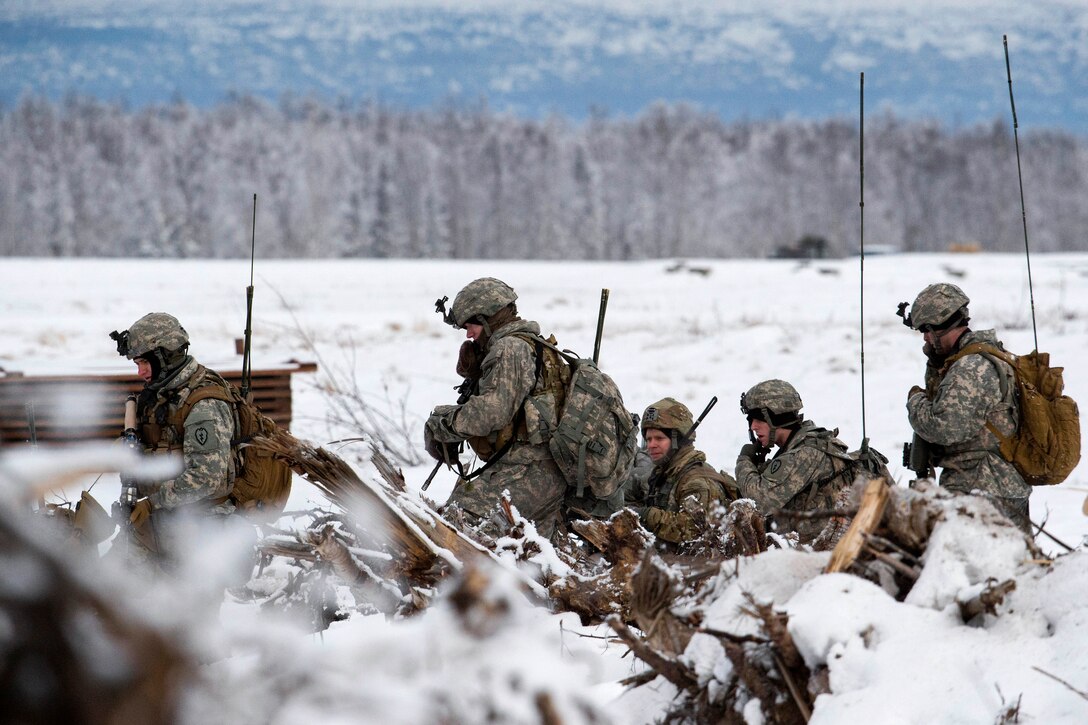 Soldiers advance move in a group in the snow.