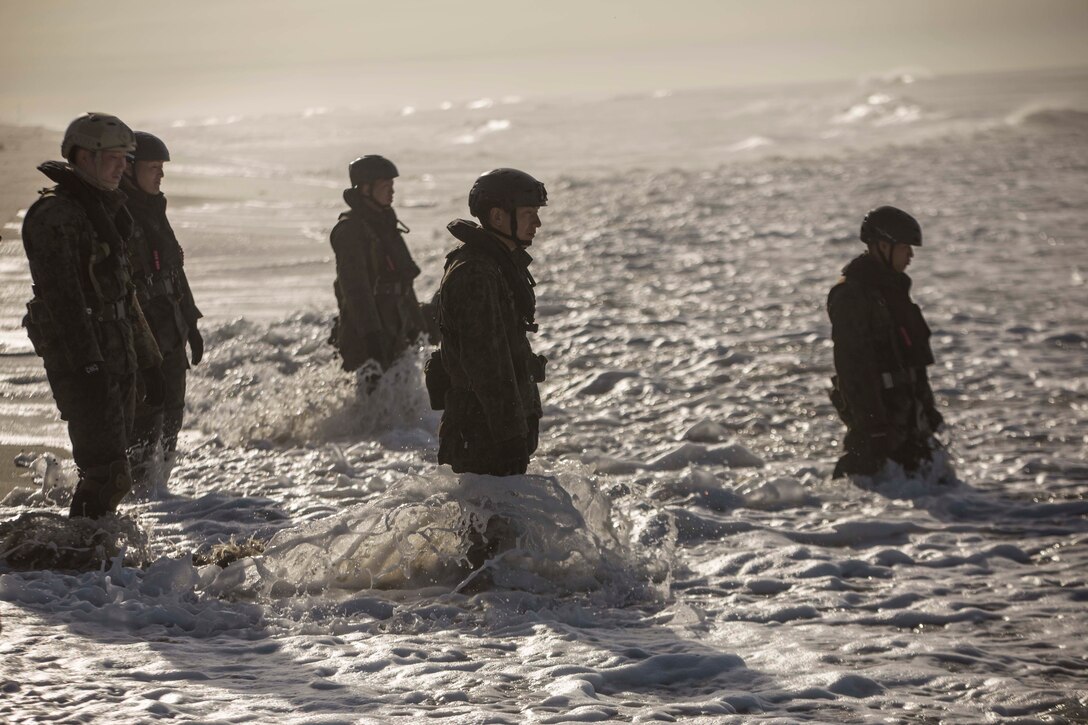 MARINE CORPS BASE CAMP PENDLETON, Calif. – Soldiers with the Western Army Infantry Regiment, Japan Ground Self Defense Force, stand by to help pull a combat rubber raiding craft on shore at Marine Corps Base Camp Pendleton during helocast training during exercise Iron Fist 2018, Jan. 18. Helocasting is a technique where a CRRC and reconnaissance Marines are loaded into a helicopter before being dropped into the ocean to make their final advancement to an objective area. This technique allows reconnaissance teams to travel longer distances from naval shipping than what a CRRC could do on its own. The Japanese Soldiers and U.S. Marines have trained together in Southern California via this annual, bilateral exercise for 13 consecutive years.