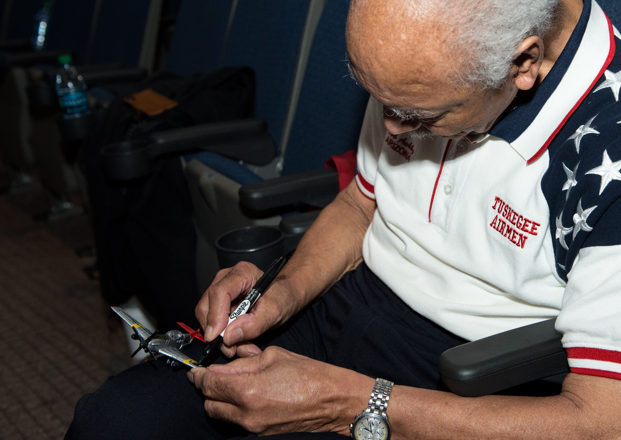 Retired Lt. Col. Robert Ashby, Tuskegee Airman, autographs a toy model P-47 Thunderbolt during the 2018 Tuskegee Airmen Honor Event at Luke Air Force Base, Ariz., Feb. 15, 2018. The Tuskegee Airmen were the first black military aviators in the U.S. Army Air Corps who performed more than 15,000 combat sorties, including 200 escort missions, earning them more than 850 service medals. (U.S. Air Force photo/ Airman 1st Class Alexander Cook)