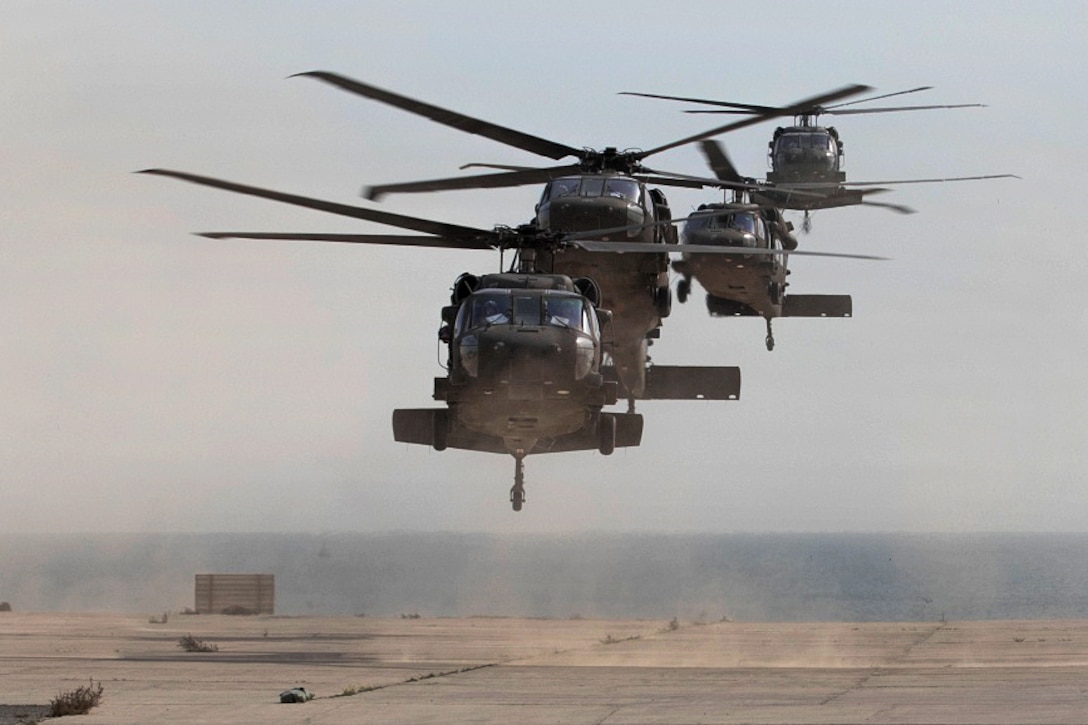 Four UH-60 Black Hawk helicopters fly in formation.