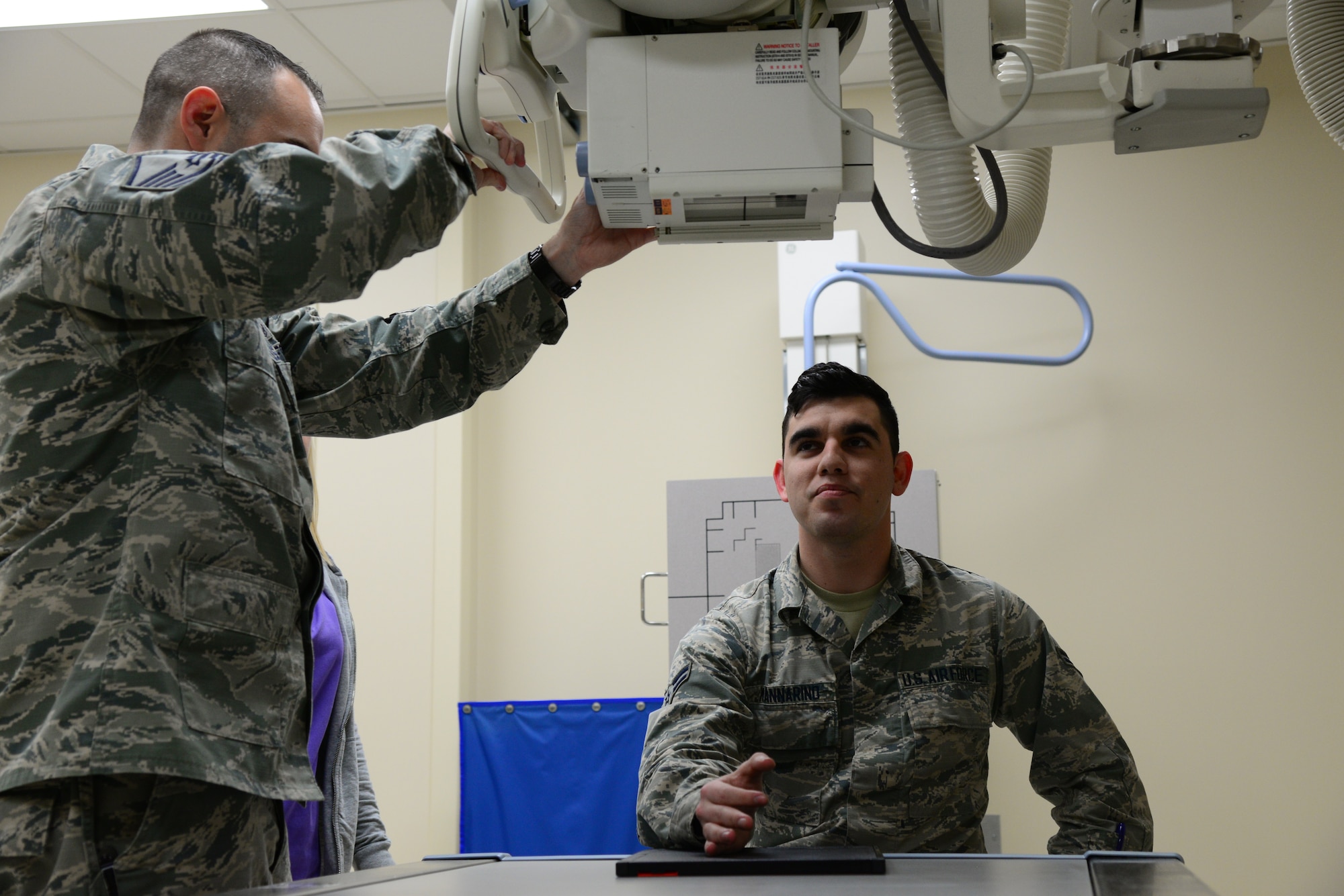 Airman 1st Class Michael Mannarino, 14th Medical Operations Squadron bioenvironmental engineer apprentice, simulates getting an X-ray Feb. 14, 2018, on Columbus Air Force Base, Mississippi. The X-ray machine works by taking 220 volts from the wall outlet and then amplify it to 100,000-140,000 volts by utilizing a transformer like machine. (U.S. Air Force photo by Airman 1st Class Beaux Hebert)