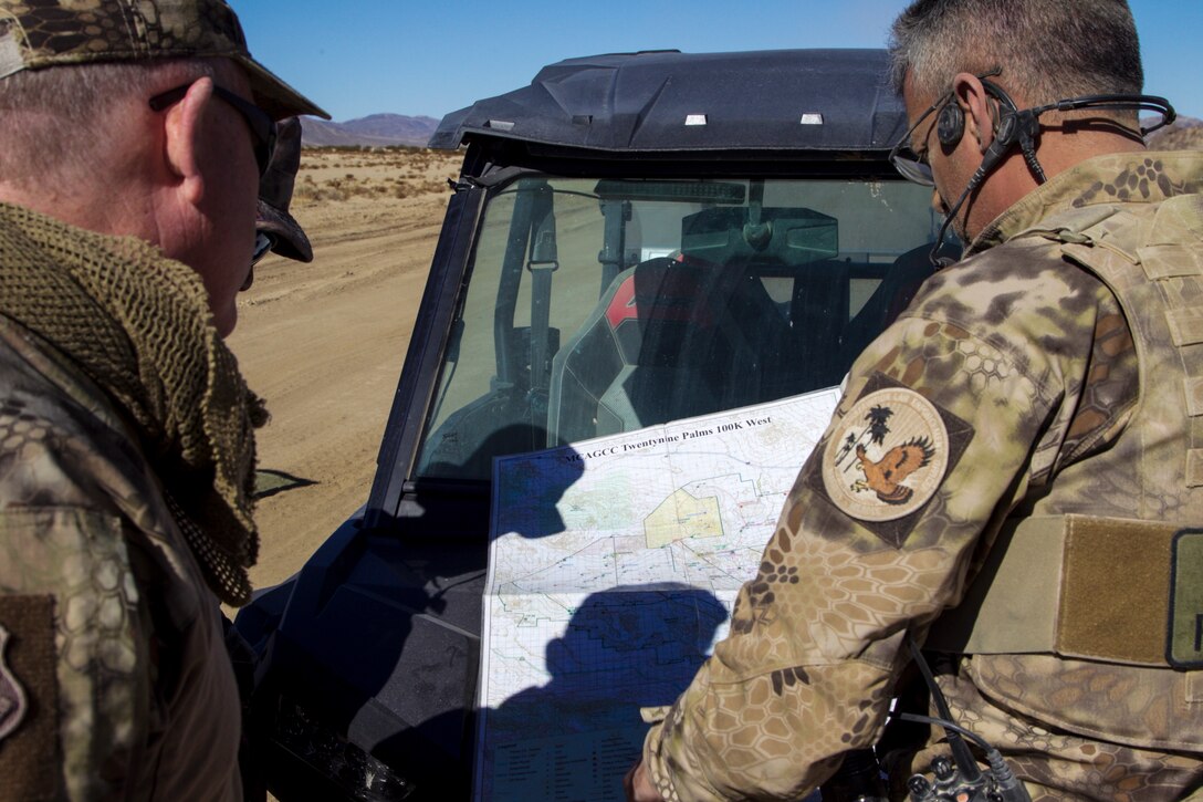 Conservation Law Enforcement Officers discuss patrol routes to prevent incursions onto the Marine Corps Air Ground Combat Center, Twentynine Palms, Calif., during the King of the Hammers off-road racing and rock-crawling event, Feb. 7, 2018. CLEOs work to help protect and preserve the base's many natural and cultural resources. (U.S. Marine Corps photo by Cpl. Dave Flores)