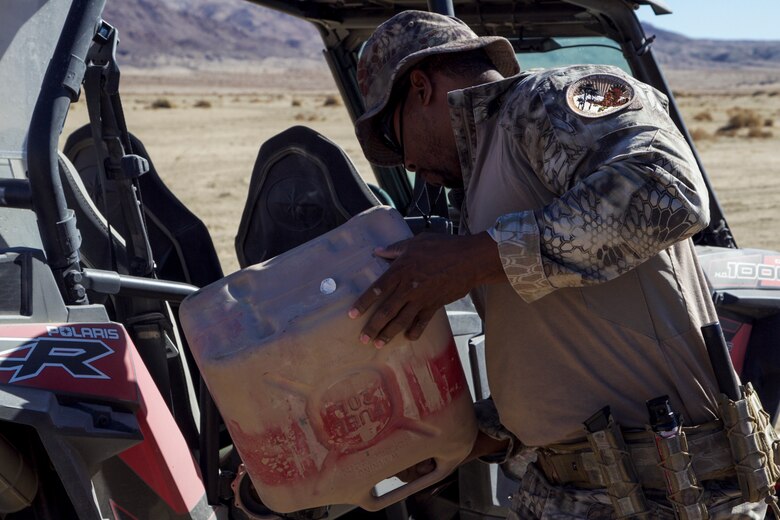 Jovan Roberts, conservation law enforcement officer, Environmental Affairs, refuels an off-road utility vehicle before embarking on a patrol aboard the Marine Corps Air Ground Combat Center, Twentynine Palms, Calif., during the King of the Hammers off-road racing and rock-crawling event, Feb. 7, 2018. CLEOs work to protect and preserve the base's many natural and cultural resources. (U.S. Marine Corps photo by Cpl. Dave Flores)