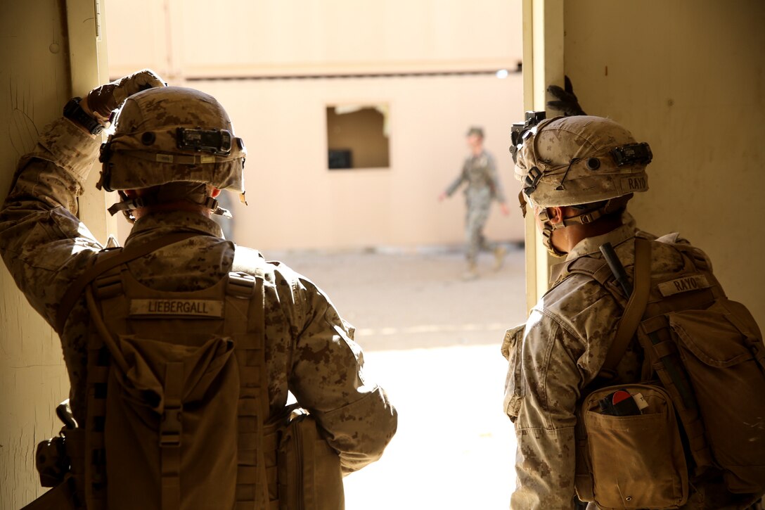 Cpl. Erik Liebergall, team leader, 3rd Battalion, 7th Marine Regiment, and Cpl. Jose Rayo, squad leader, 3/7, communicate between buildings with fellow Marines at Range 220 aboard the Marine Corps Air Ground Combat Center Twentynine Palms, Calif., Feb. 9, 2018 as part of Integrated Training Exercise 2-18. The purpose of ITX is to create a challenging, realistic training environment that produces combat-ready forces capable of operating as an integrated MAGTF. (U.S. Marine Corps photo by Lance Cpl. Margaret Gale)