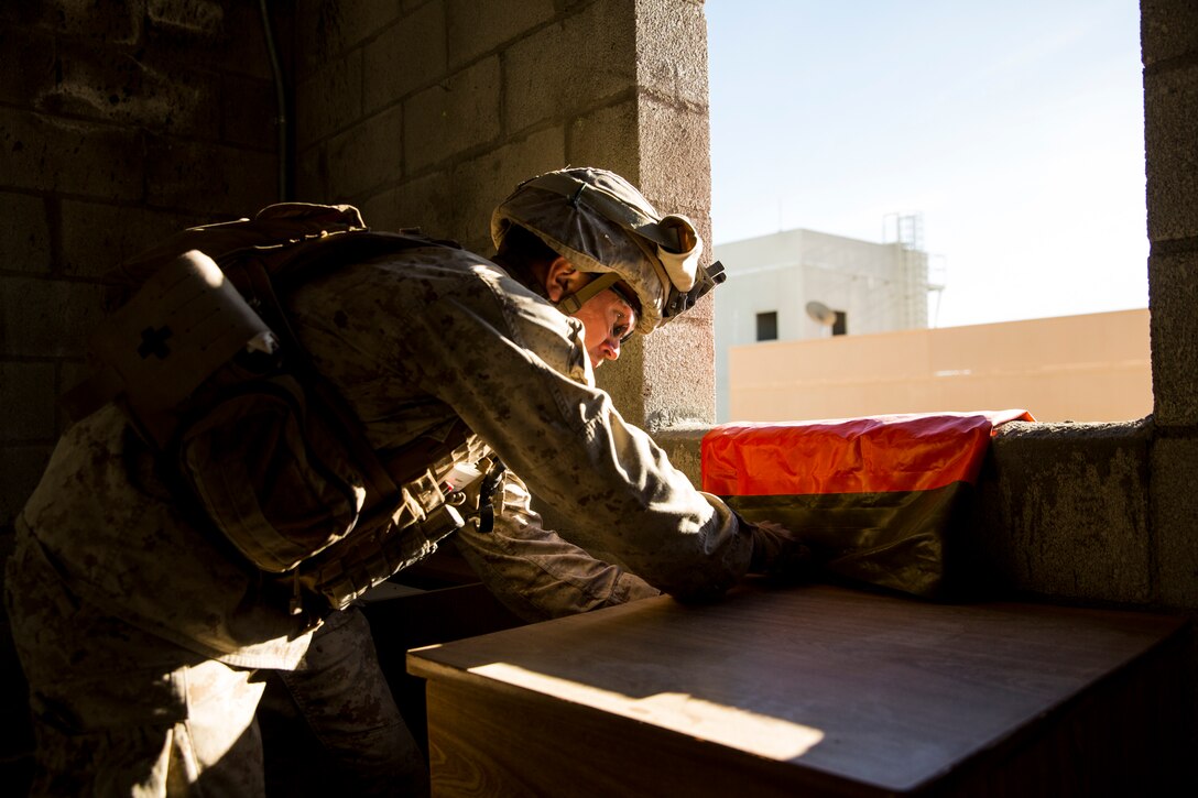 A Marine with 3rd Battalion, 7th Marine Regiment, drapes a marking flag out of a building for medical vehicles to locate the casualties at Range 220 aboard the Marine Corps Air Ground Combat Center Twentynine Palms, Calif., Feb. 9, 2018 as part of Integrated Training Exercise 2-18. The purpose of ITX is to create a challenging, realistic training environment that produces combat-ready forces capable of operating as an integrated MAGTF. (U.S. Marine Corps photo by Lance Cpl. Margaret Gale)