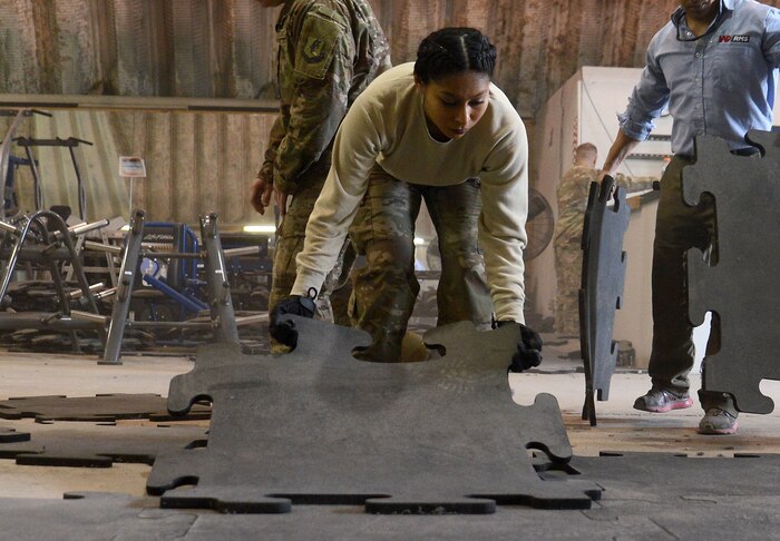 Senior Airman Astrid Hernandez, 455th Expeditionary Force Support Squadron contracting officer representative, lays flooring in the Warrior Fitness Center Feb. 10, 2018 at Bagram Airfield, Afghanistan.