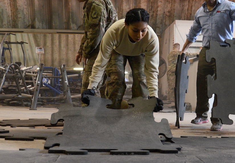 Senior Airman Astrid Hernandez, 455th Expeditionary Force Support Squadron contracting officer representative, lays flooring in the Warrior Fitness Center Feb. 10, 2018 at Bagram Airfield, Afghanistan.