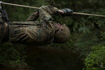 Lance Cpl. Daron Bush, a network administrator with Communications Company, Headquarters Regiment, 3rd Marine Logistics Group, pulls himself across a cable during the Endurance Course on Camp Gonsalves, Okinawa, Japan, Feb. 16, 2018. Marines of Comm. Co. participated in the Basic Jungle Skills Course at the Jungle Warfare Training, which teaches Marines how to operate in a jungle environment. Bush is a native of Saint Mary’s County, Maryland. (U.S. Marine Corps photo by Lance Cpl. Jamin M. Powell)