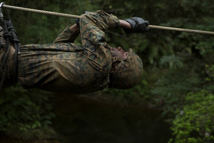 Lance Cpl. Daron Bush, a network administrator with Communications Company, Headquarters Regiment, 3rd Marine Logistics Group, pulls himself across a cable during the Endurance Course on Camp Gonsalves, Okinawa, Japan, Feb. 16, 2018. Marines of Comm. Co. participated in the Basic Jungle Skills Course at the Jungle Warfare Training, which teaches Marines how to operate in a jungle environment. Bush is a native of Saint Mary’s County, Maryland. (U.S. Marine Corps photo by Lance Cpl. Jamin M. Powell)