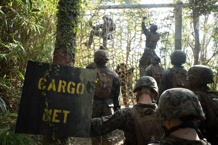 Marines with Communications Company, Headquarters Regiment, 3rd Marine Logistics Group climb over the cargo net, one of the obstacles in the Endurance Course at Camp Gonsalves, Okinawa, Japan, Feb. 16, 2018. The E-Course is the culminating event in the Basic Jungle Skills Course, consisting of obstacles scattered through the hill-riddled jungle. BJSC is designed to teach Marines how to operate in a jungle environment. (U.S. Marine Corps photo by Lance Cpl. Jamin M. Powell)