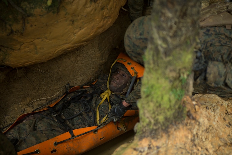 Lance Cpl. Daron Bush, a network administrator with Communications Company, Headquarters Regiment, 3rd Marine Logistics Group, acts as a simulated casualty during an Endurance Course run on Camp Gonsalves, Okinawa, Japan, Feb. 16, 2018. Marines of Comm. Co. participated in the Basic Jungle Skills Course at the Jungle Warfare Training Center, which teaches Marines how to operate in a jungle environment. Bush is a native of Leonardtown, Maryland. (U.S. Marine Corps photo by Lance Cpl. Jamin M. Powell)