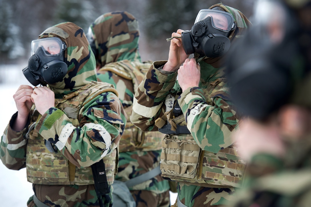 Airmen don protective gear before a live-fire demolitions exercise.