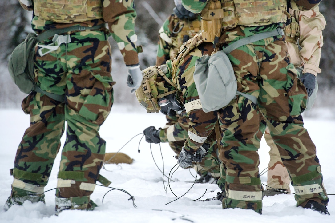 Airmen prepare detonation cord and charges for a live-fire demolitions exercise.