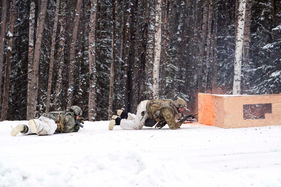 Soldiers crawl toward a breached enemy position during a live-fire exercise.