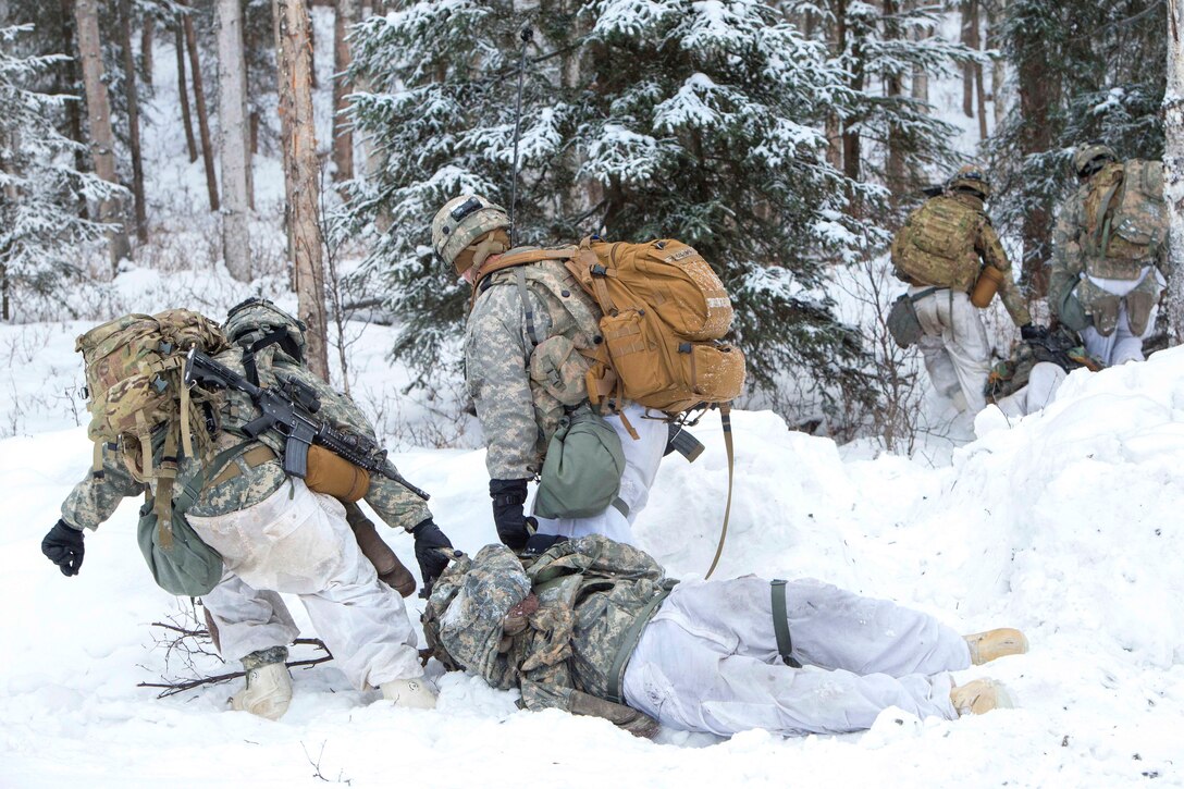 Soldiers evacuate simulated casualties after assaulting an objective.