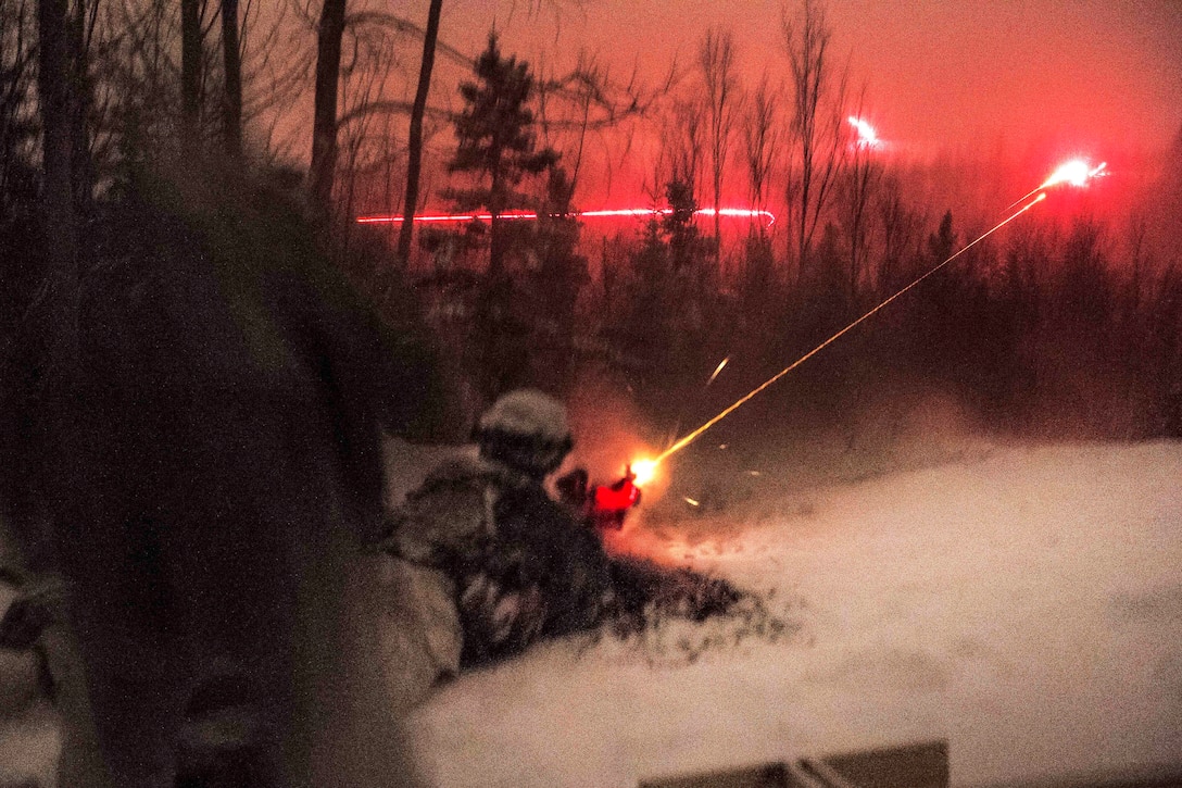 Tracer fire illuminates the sky as soldiers provide fire support during a night assault exercise.