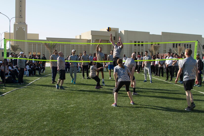 Service members from the U.S. and Qatar play volleyball.