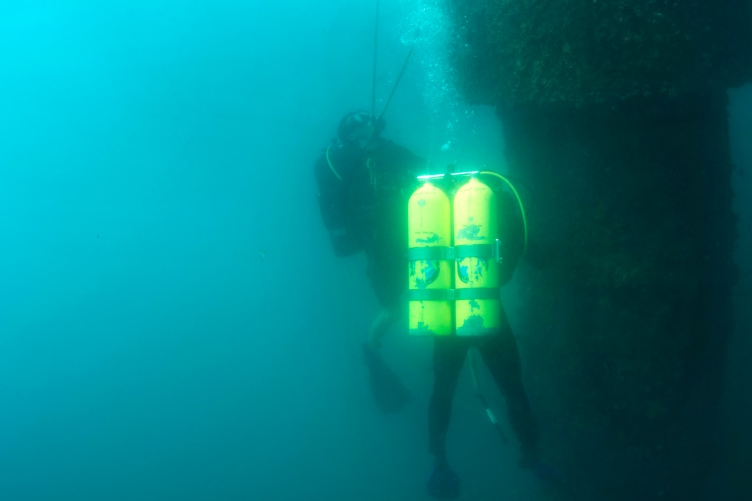 U.S. and Thai navy divers conduct a pier assessment.