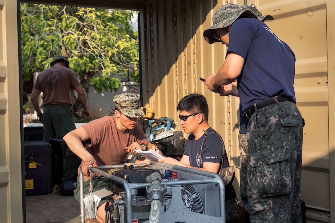 A Navy seaman speaks with South Korean divers at the Thai Navy Diving School.