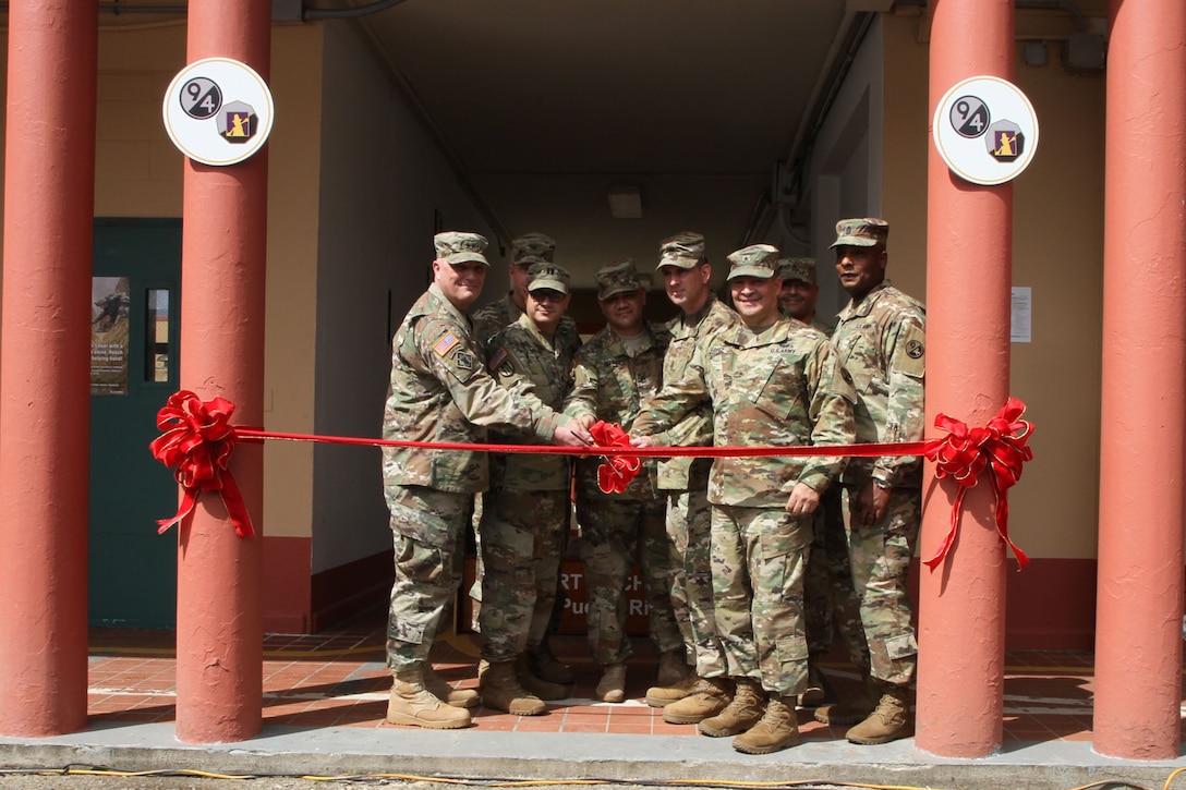 Maj. Gen. Bruce Hackett, commanding General of the 80th Training Command, and Brig. Gen. Hector Lopez, commanding general of the 94th Training Division, take part in the ribbon-cutting ceremony at Fort Buchanan, Puerto Rico to celebrate the reopening and relocation of a schoolhouse for the 94th Training Division's 5th Battalion on 13 February 2018. The 5th BN's previous schoolhouse was severely damaged by the devastation of Hurricane Maria. Maj. Gen. Hackett and Brig. Gen. Lopez were also on the island to assist with the planned tranistion and approved reassignment of all units stationed in Puerto Rico to the operational control of the 1st Mission Support Command.

Photo by Army Master Sgt. Benari Poulten, 80th Training Command (TASS) Public Affairs