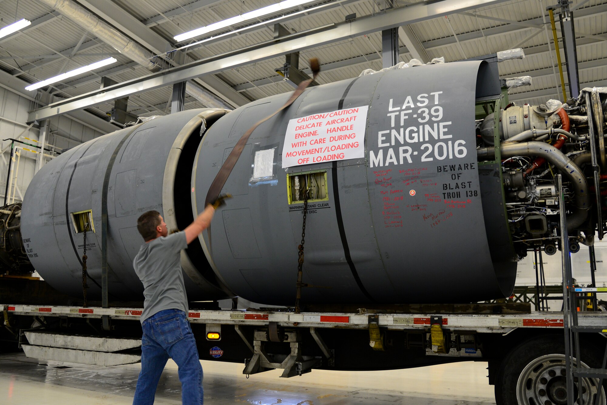Wesley Currin, Triple J Trucking driver, throws a tie-down strap over a General Electric TF-39 turbofan engine Feb. 16, 2018, at Dover Air Force Base, Del. The North Carolina native drove the Air Force’s last functional TF-39 engine to Monroe, N.C., where it was purchased by a metals reclamation company. (U.S. Air Force photo by Staff Sgt. Aaron J. Jenne)