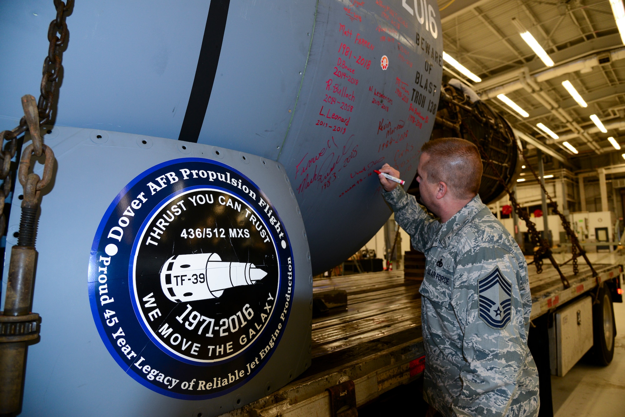 Chief Master Sgt. Vincent Alois, 512th Maintenance Group superintendent, signs General Electric TF-39 turbofan engine 411052 before its final departure Feb. 16, 2018, at Dover Air Force Base, Del. Since 1971, Airmen at the Jet Engine Intermediate Level Maintenance shop maintained the TF-39 engines from across the Air Force. (U.S. Air Force photo by Staff Sgt. Aaron J. Jenne)