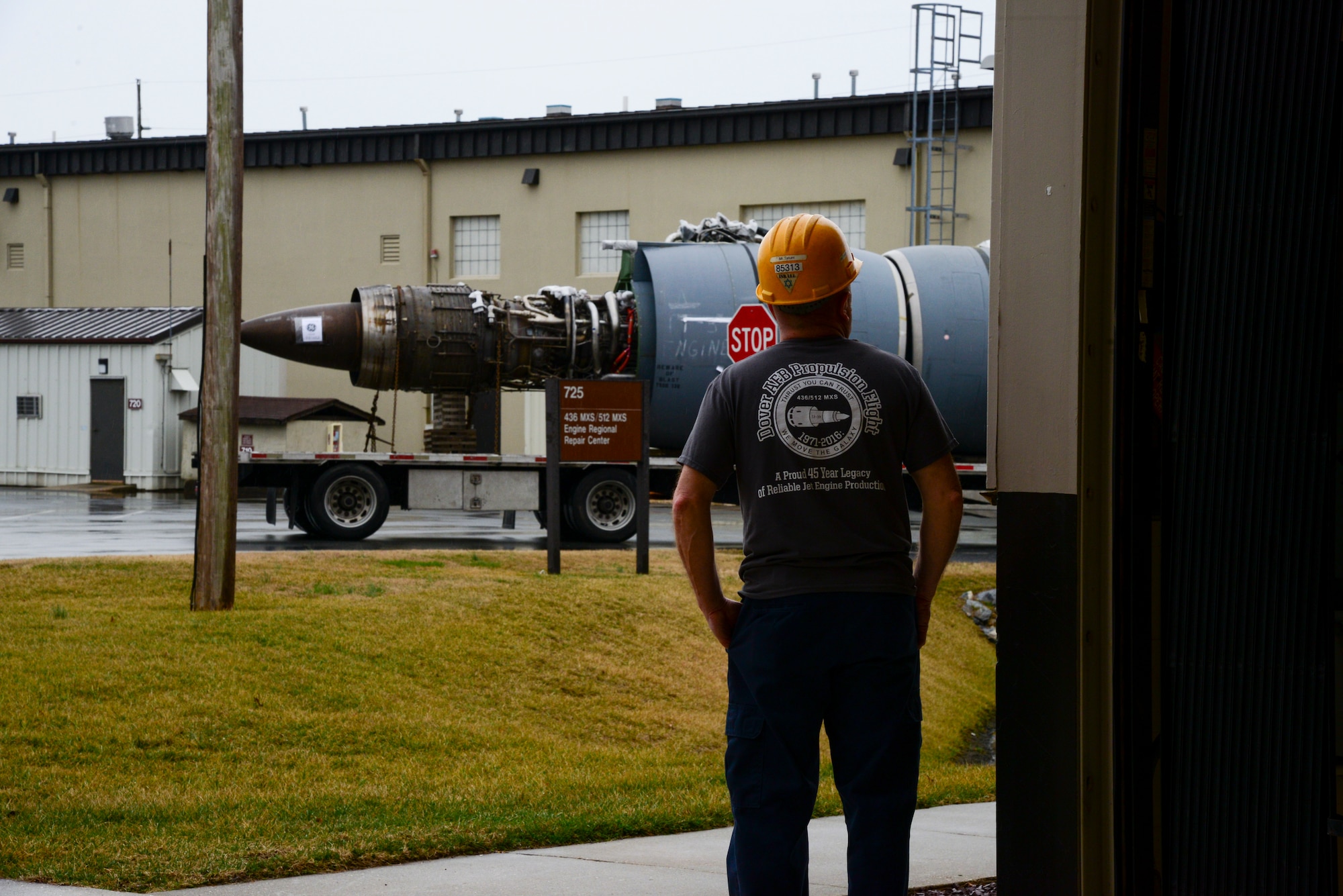 Michael Tatum, 436th Maintenance Group aerospace propulsion engine mechanic, watches from the Jet Engine Intermediate Level Maintenance Shop building as the last production General Electric TF-39 turbofan engine rolls away Feb. 16, 2018. As the C-5A/B Galaxies were modernized, the TF-39 engines were exchanged for GE CF6-80 engines, and the members of the JEIM shop began preparing the legacy TF-39 engines to be sold. (U.S. Air Force photo by Staff Sgt. Aaron J. Jenne)