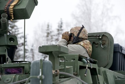 A Soldier assigned to Bayonet Company, 1st Battalion, 5th Infantry Regiment, 1st Stryker Brigade Combat Team, 25th Infantry Division, U.S. Army Alaska, surveys the surrounding area while preparing for live-fire gunnery training during Operation Punchbowl at Joint Base Elmendorf-Richardson, Alaska, Feb. 16, 2018. Operation Punchbowl was a battalion-level, combined arms, live-fire exercise that focused on arctic lethality.