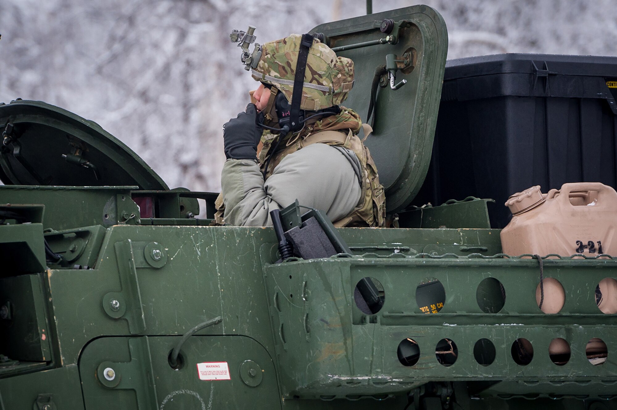 Army 1st Lt. Daniel Choi, a vehicle commander assigned to Bayonet Company, 1st Battalion, 5th Infantry Regiment, 1st Stryker Brigade Combat Team, 25th Infantry Division, U.S. Army Alaska, communicates with his crew as they prepare to maneuver onto the range for gunnery on Joint Base Elmendorf-Richardson, Alaska, during Operation Punch Bowl. The Fort Wainwright based Soldiers' operation culminated with multiple live-fire and combat training events.