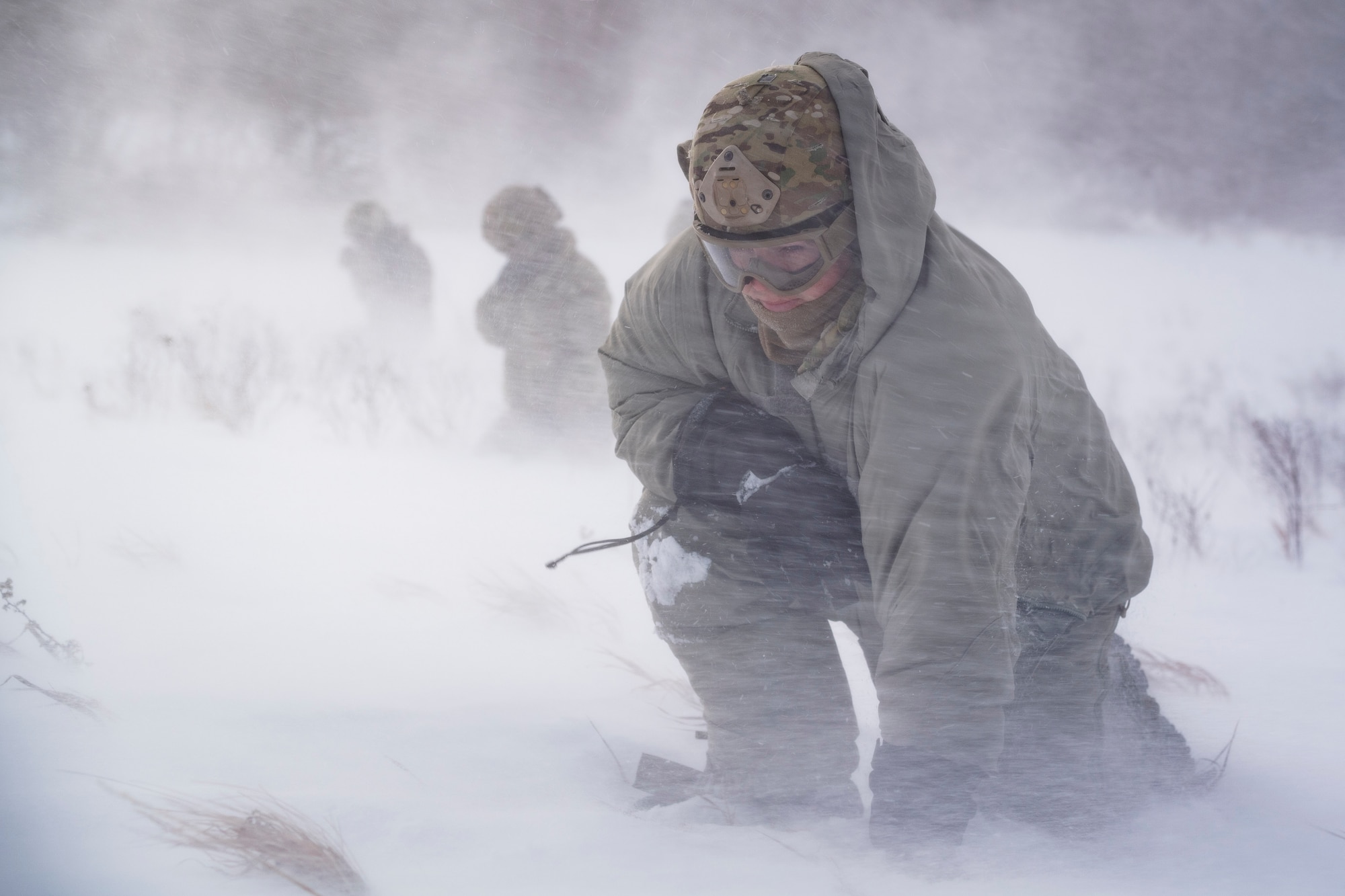 Staff Sgt. Benjamin Reynolds, 891st Missile Security Forces Squadron response force leader, crouches in rotor wash inside the Turtle Mountain State Forest, N.D., Feb. 14, 2018, during a field training exercise. During the exercise, 91st Security Forces Group defenders coordinated simulated medical evacuations with two 54th Helicopter Squadron UH-1N Iroquois. (U.S. Air Force photo by Senior Airman J.T. Armstrong)