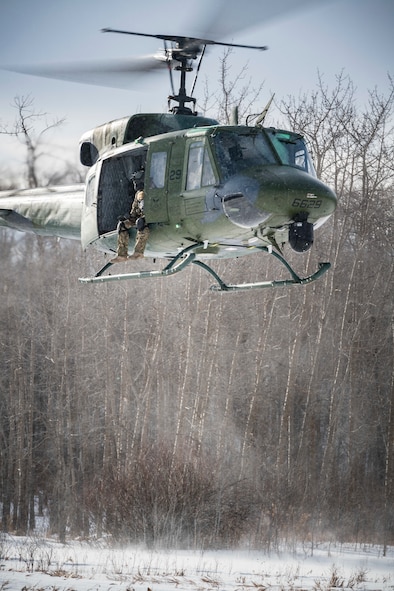 A 54th Helicopter Squadron UH-1N Iroquois hovers over the Turtle Mountain State Forest, N.D., Feb. 14, 2018, during a 91st Security Forces Group field training exercise. During the FTX, defenders vectored the aircraft to a landing zone and performed a simulated medical evacuation. (U.S. Air Force photo by Senior Airman J.T. Armstrong)
