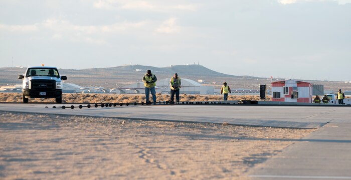 An Edward F-16 catches the arresting cable on an Edwards runway as part of a certification engagement of a newly overhauled aircraft arresting system Jan. 25. Members of the 412th Civil Engineer Squadron began installing the new system last November. (U.S. Air Force photo by Brad White)