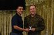 U.S. Air Force Col. Ricky Mills, 17th Training Wing commander, awards U.S. Marine Corps. Pfc. Jared Armes, Marine Corps Detachment trainee, with the 2nd place trophy during the 11th Annual Talent Show at the Crossroads on Goodfellow Air Force Base, Texas, Feb. 16, 2018. Armes played guitar and sang to an original song called ‘Wayside’. (U.S. Air Force Photo by Airman 1st Class Zachary Chapman/Released)