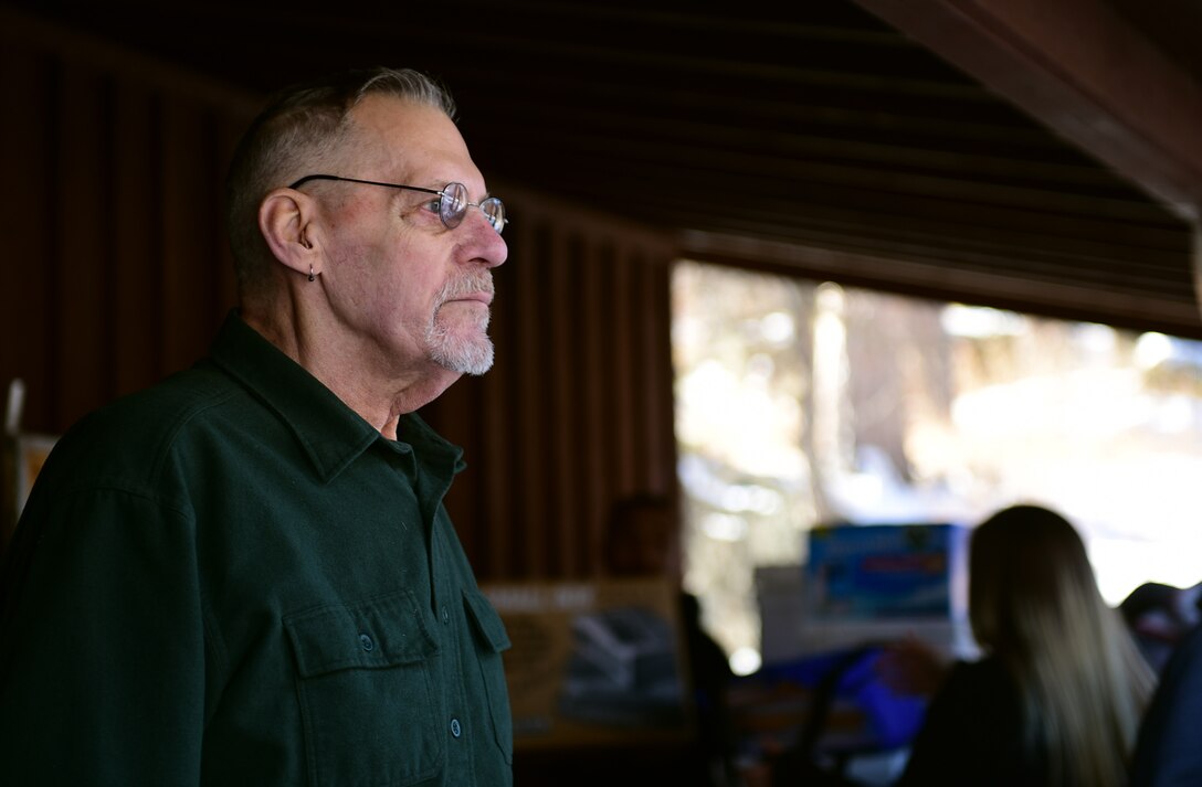 Clint Simmons, a four-time cancer survivor, watches as Airmen from Ellsworth Air Force Base, S.D., help pack his belongings near Rockerville on Feb. 17, 2018. Twenty-seven Airmen volunteered to spend their Saturday morning assisting the Simmons family with their last-minute move to Florida.  (U.S. Air Force photo by Senior Airman James L. Miller)