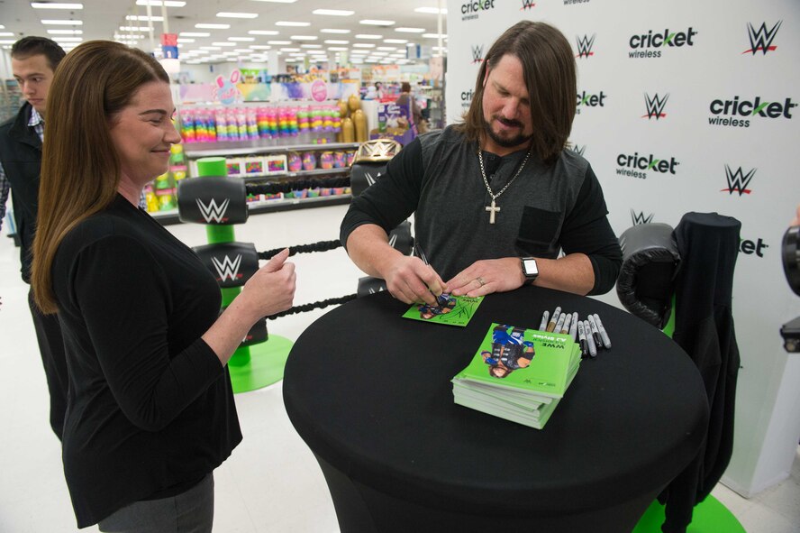 AJ Styles, World Wrestling Entertainment professional athlete, autographs a card for a fan at Luke Air Force Base, Ariz., Feb. 20, 2018. Airmen brought various items and memorabilia for Styles to autograph during the meet-and-greet event. (U.S. Air Force photo/Airman 1st Class Caleb Worpel)