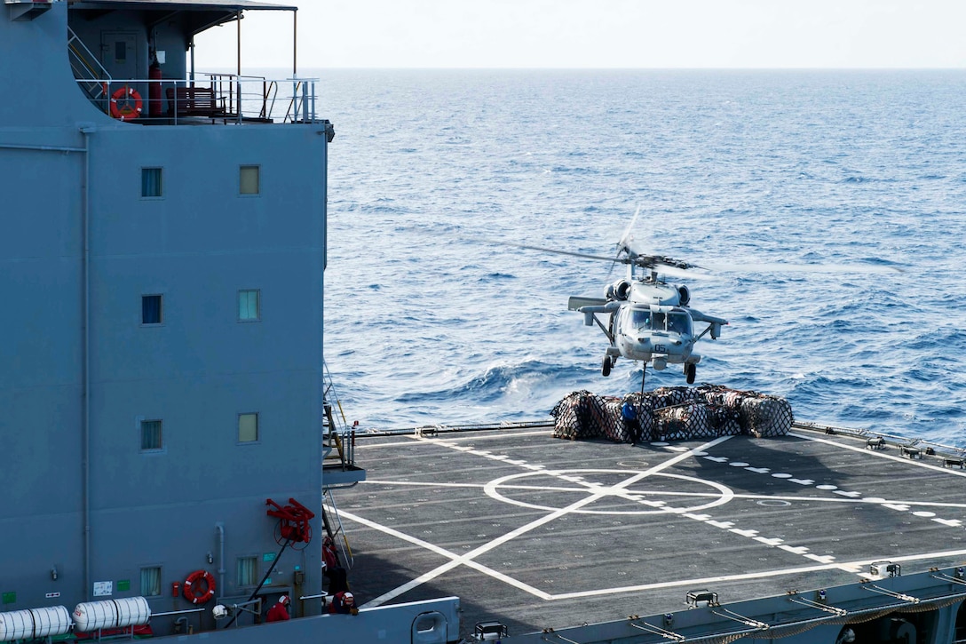 An MH-60S Seahawk takes off with cargo.