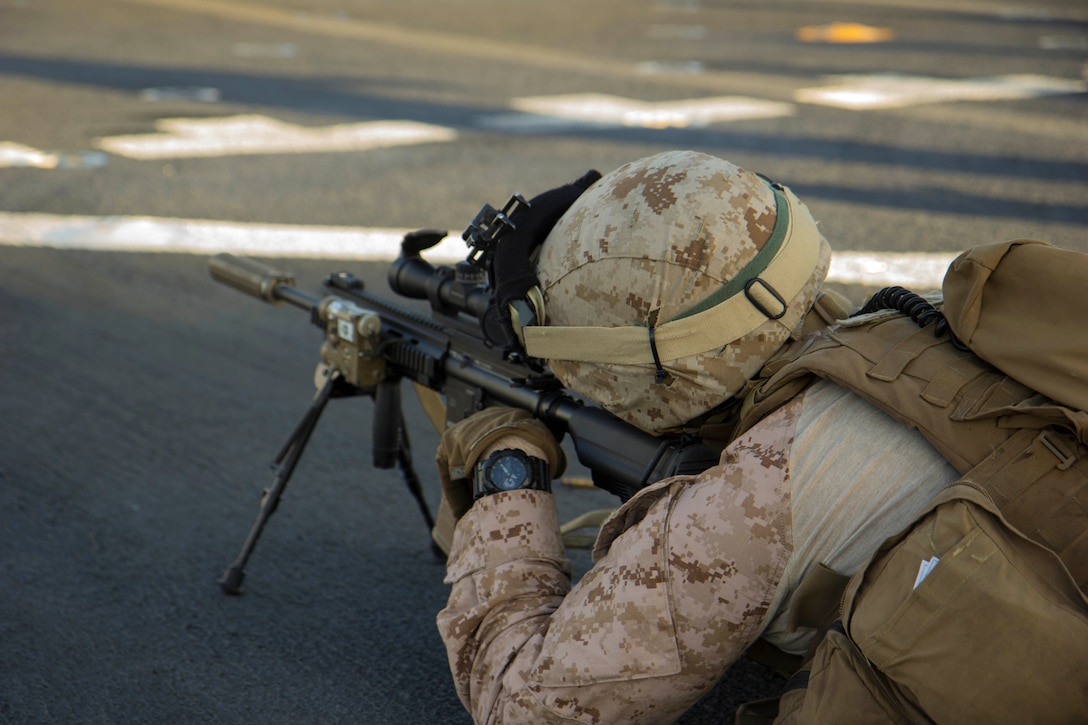 A U.S. Marine with Battalion Landing Team, 2nd Battalion, 6th Marine Regiment, 26th Marine Expeditionary Unit (MEU) fires his M4 carbine rifle during a deck shoot.