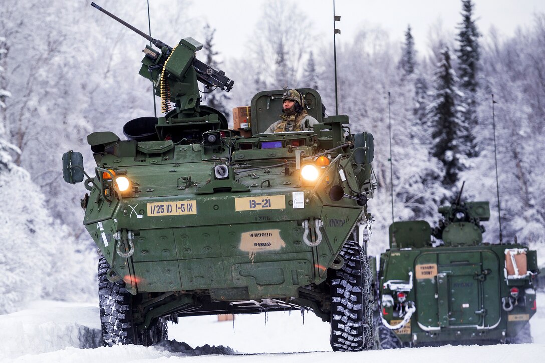 Soldiers maneuver a Stryker armored vehicle through the snow.